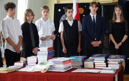 uczniowie przy stoliku z książkami