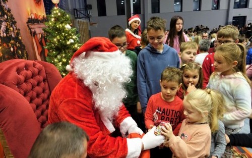 Święty Mikołaj rozdaje dzieciom prezenty